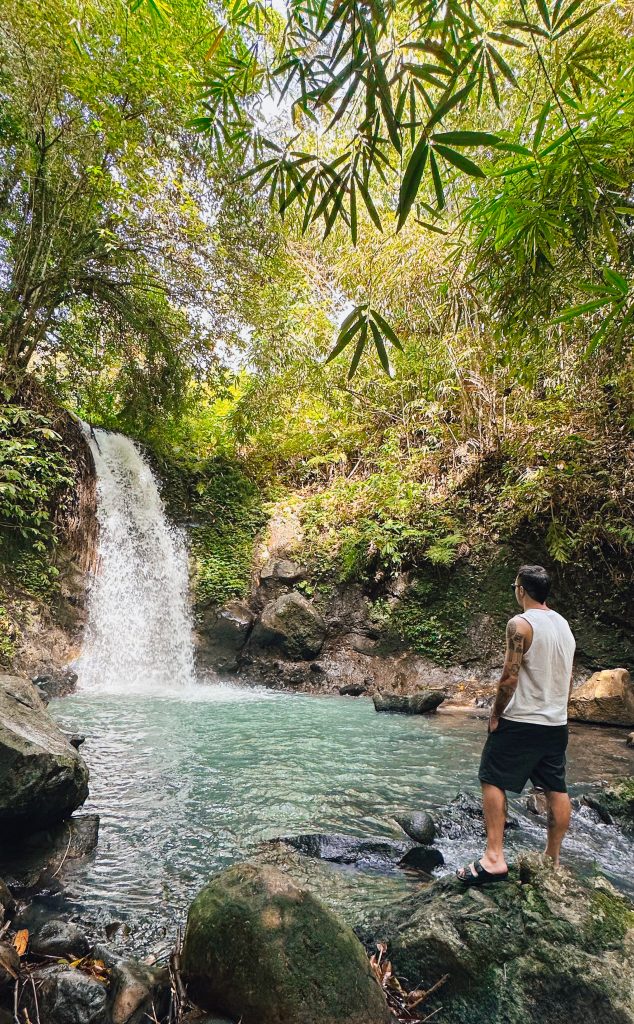 ragazzo davanti a cascata Bali - Atypical Vibes